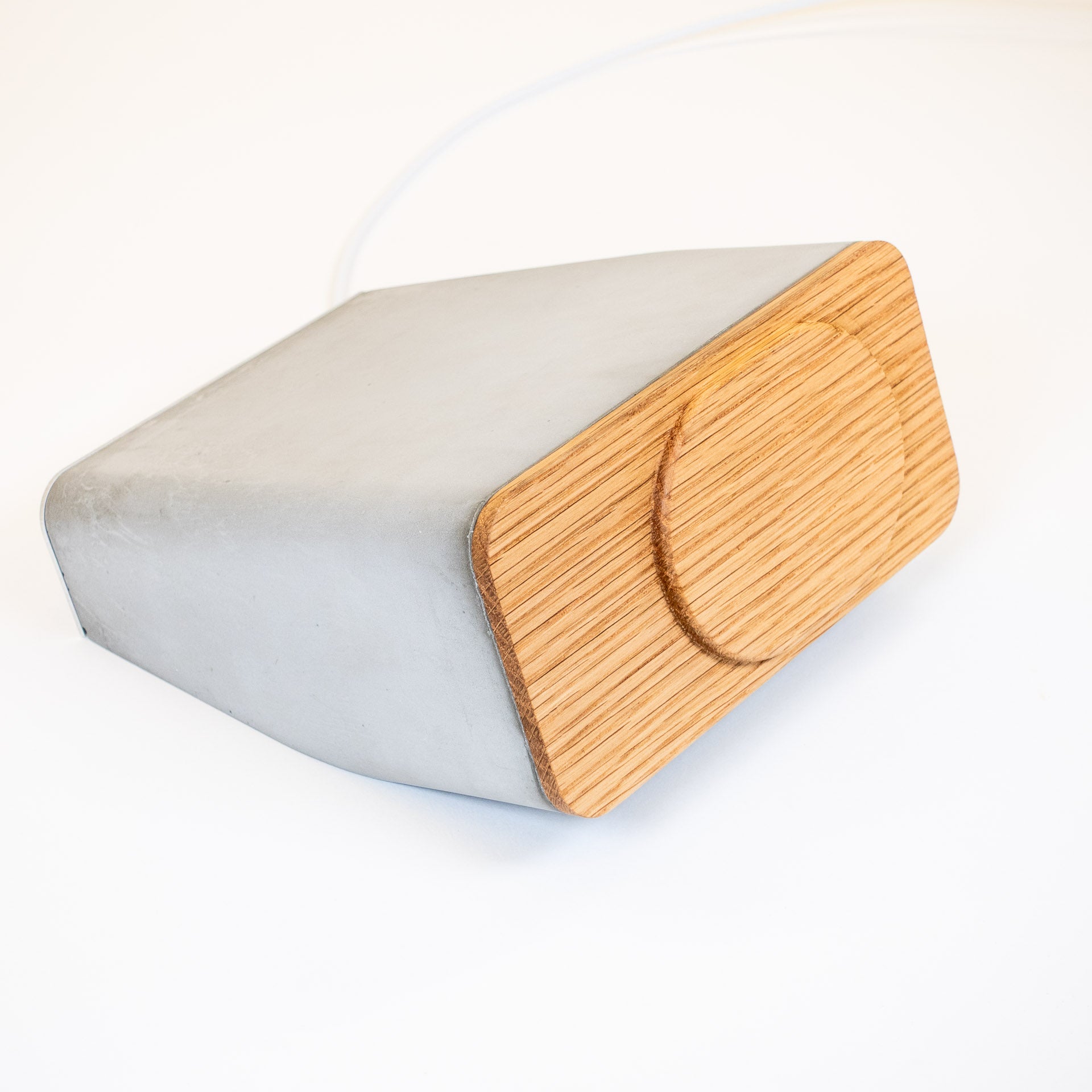 Flatlay of architectural MagSafe iPhone charger in white oak and concrete