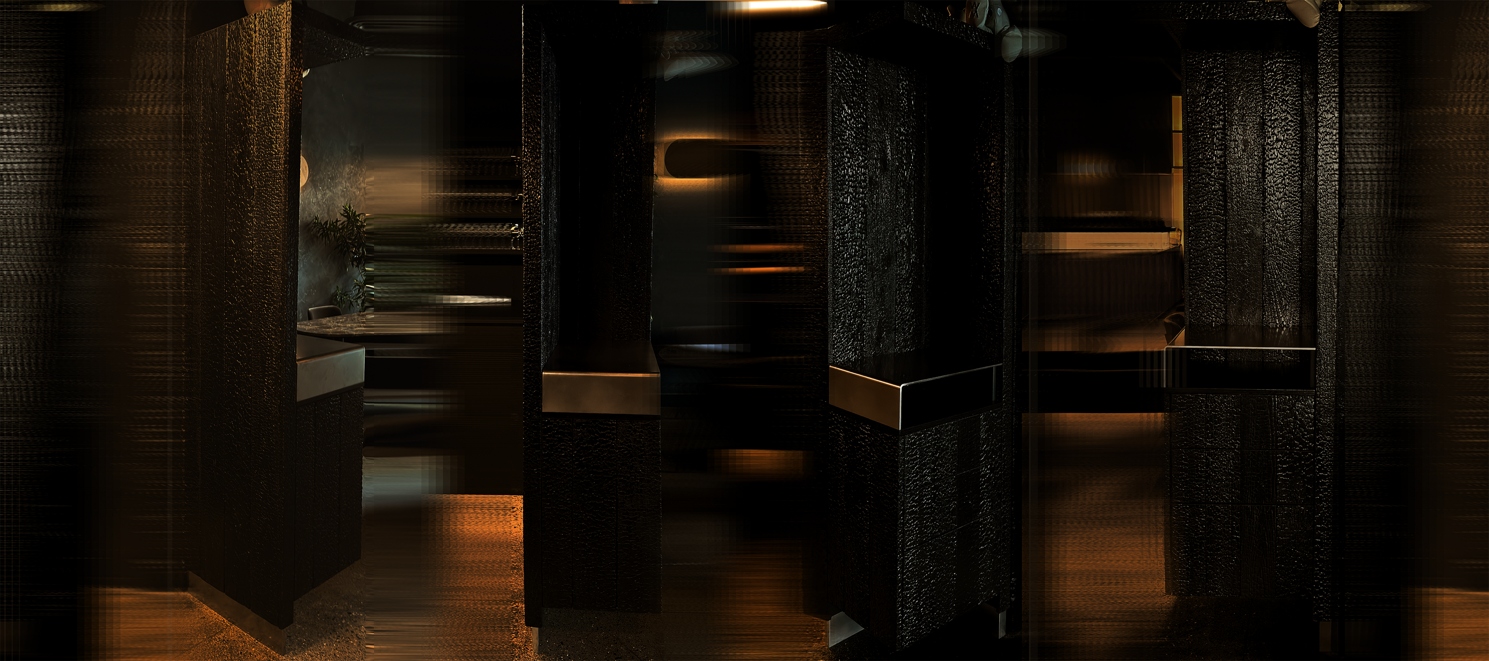 Charred wood hospitality furniture piece with stainless steel top and base kick, designed as custom restaurant millwork installation.