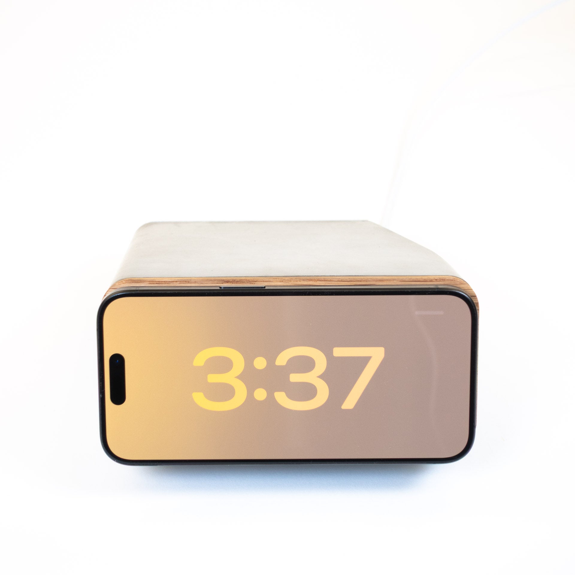 iPhone charging horizontally on MagSafe stand in StandBy mode with minimalist design