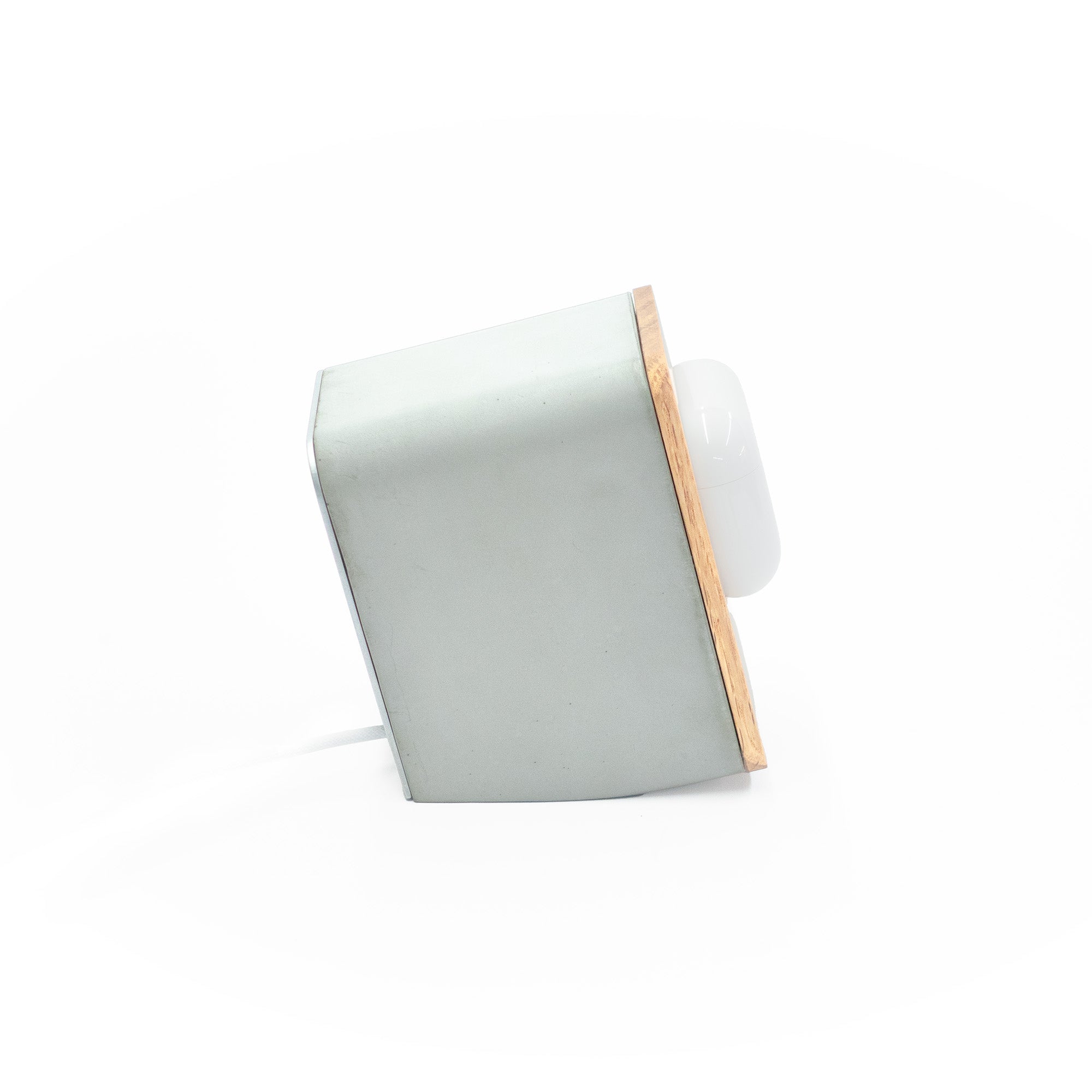 Side profile of Brutalist concrete AirPods Pro MagSafe dock showing solid architectural form and integrated magnetic charging system.