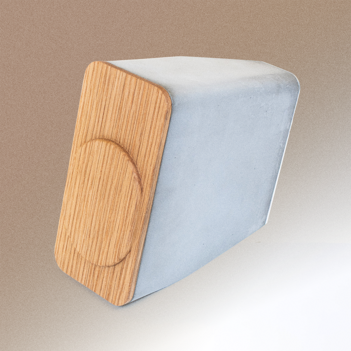 Angled view of brutalist MagSafe charger made from concrete and white oak, designed as a sculptural desk accessory for modern interiors.